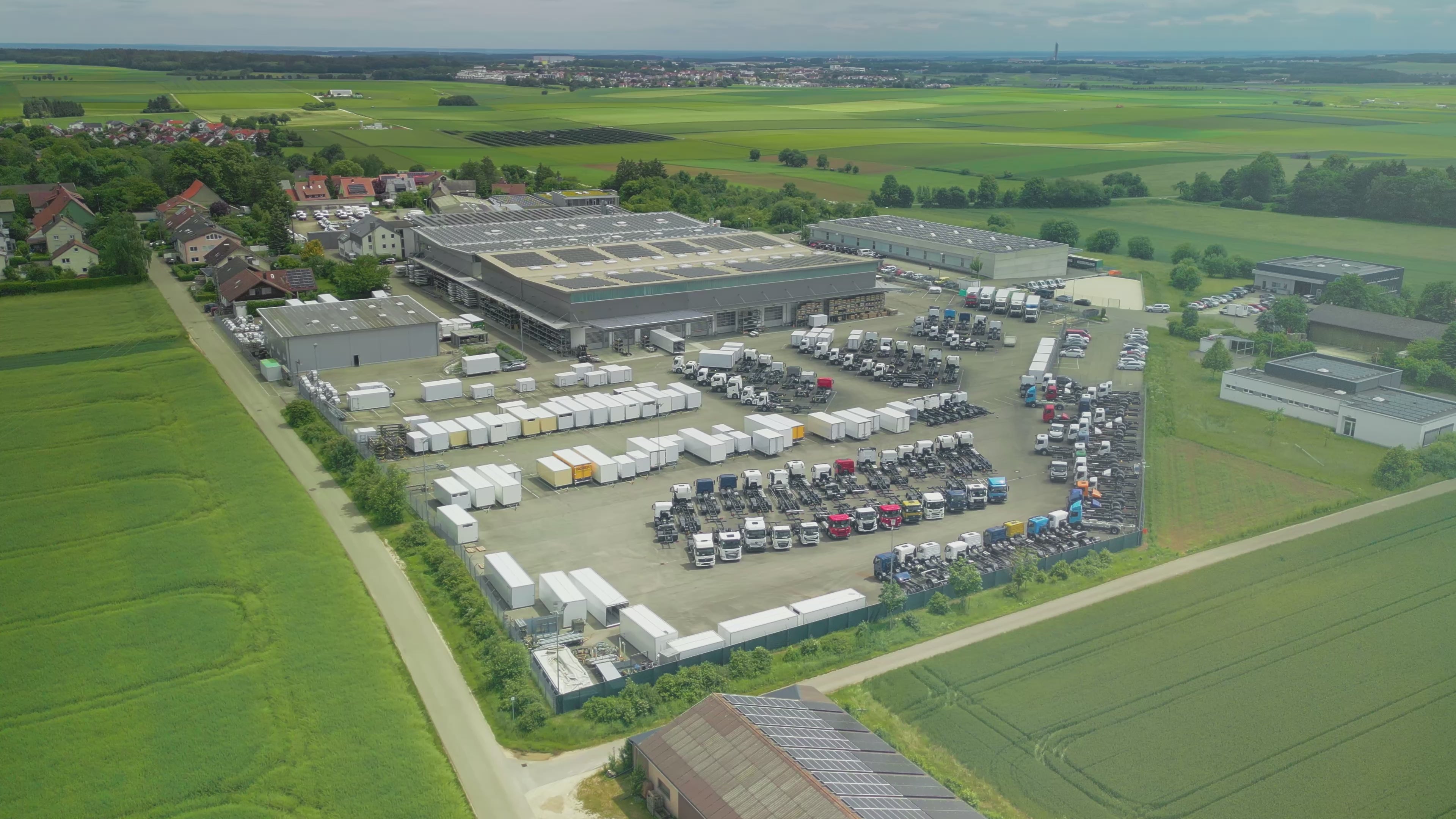 Video laden: Video über das Werk Kiesling in Dornstadt-Tomerdingen bei Ulm mit Produktionsanlagen, Drohnenbilder eines Lagerplatzes für Kühlfahrzeuge und Bilder der Kühlfahrzeuge.